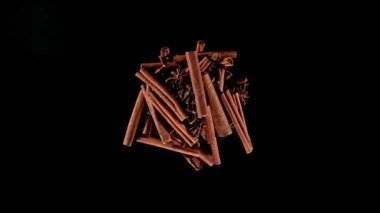 Siyah arka planda dönen tarçın kabukları ve anason anason süper yavaş çekimde. Nihai gerçekçi dönüş hareketi. Yüksek hızlı sinema kamerası, 1000fps.