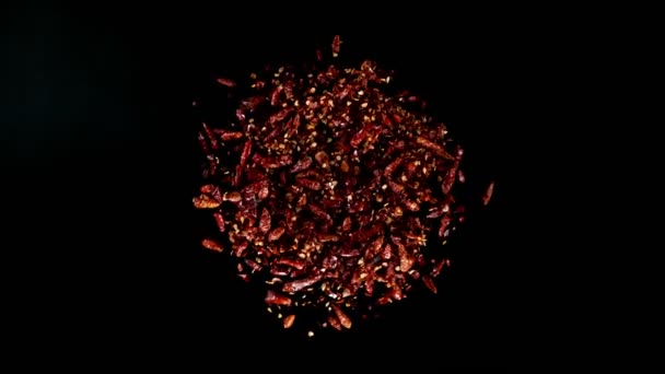 黒コショウで単離された回転唐辛子の超遅い動き 高速シネマカメラで撮影されたオーバーヘッドビュー 1000 Fps 究極の視点と空飛ぶ食べ物の概念 — ストック動画