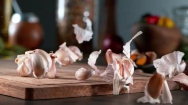 Tahta tahtada sarımsak yuvarlamanın süper yavaş çekimi. Yüksek hızlı sinema kamerası, 1000 fps. Kamera hareket kontrolünde, nesneyi takip et. Hız rampası etkisi.