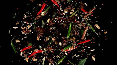 Siyah zemin üzerinde uçan baharat karışımının dondurucu hareketi. Uçan yiyecek kavramı.