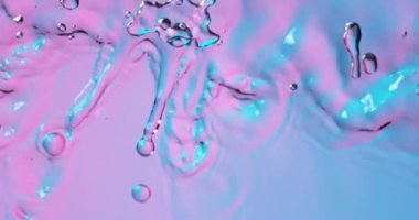 Neon ışıklarıyla aydınlatılan su dalgalarının süper yavaş akımı. Yüksek hızlı sinema kamerası, 1000 fps..