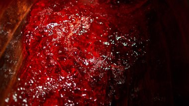 Ahşap fıçıdaki kırmızı şarabın dondurucu hareketi. Fıçının içine şarap dökme fikri. Alkolik içecek arka planı.