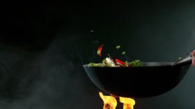Süper yavaş uçan somon eti ve tavadan Asya sebzesi. Yüksek hızlı sinema kamerası, 1000 fps. Hız rampası etkisi.