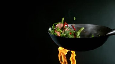 Süper yavaş uçan somon eti ve tavadan Asya sebzesi. Yüksek hızlı sinema kamerası, 1000 fps..