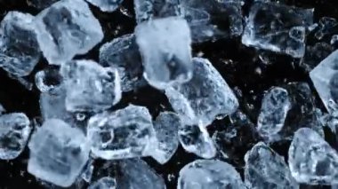 Düşen buz küplerinin süper yavaş çekim gücü siyah arkaplanda ayrılır. Yüksek hızlı sinema kamerası, 1000 fps..