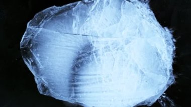 Siyah zemin üzerine düşen buz parçasının süper yavaş çekimi. Yüksek hızlı sinema kamerası, 1000 fps..