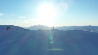 Genç adam Alplerde kayağa tırmanıyor. Kış aktivitesinin hava görüntüleri. Alpin tırmanışı, güzel karlı dağ zirveleri.