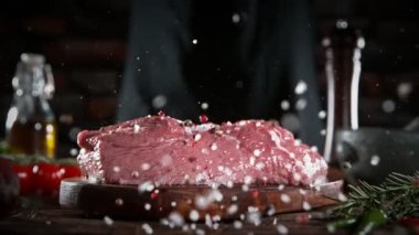 Bifteğe baharat atan şefin süper yavaş çekimi. Yüksek hızlı sinema kamerası, 1000 fps. Mutfakta et hazırlığı. Hız rampası etkisi.