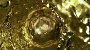 Kasırga şeklinde beyaz şarap doldurmanın süper yavaş çekimi. Yüksek hızlı sinema kamerası, 1000 fps..