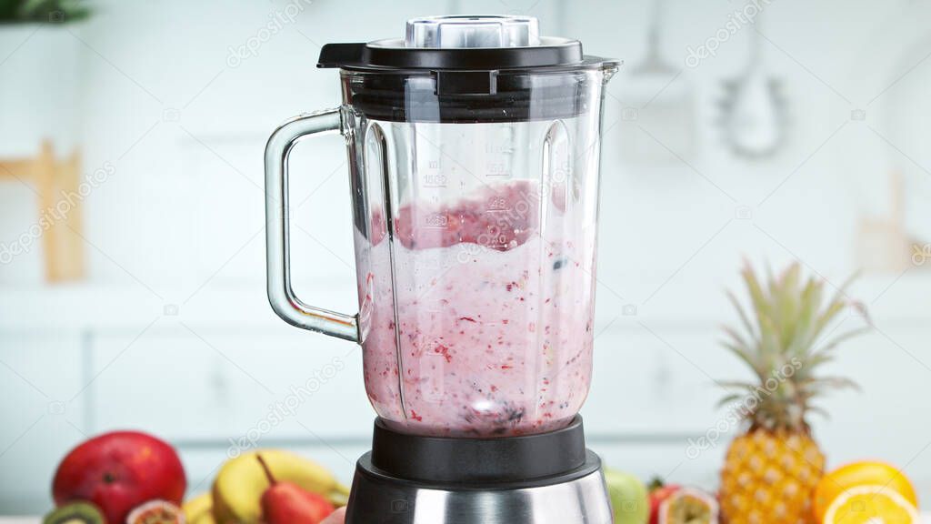 Mixing pieces of fruits and in blender. Preparation of healthy drink.