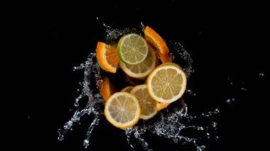 Limon, portakal ve limon dilimleri çok yavaş dönüyor. Yüksek hızlı sinema kamerası, 1000 fps. Üst çekim.