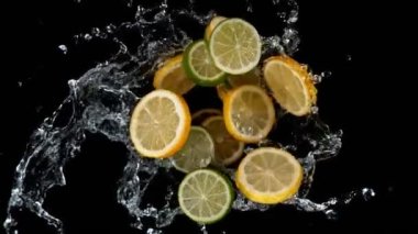 Limon dilimleri ve limon dilimleri su sıçratarak dönüyor. Yüksek hızlı sinema kamerası, 1000 fps. Üst çekim.