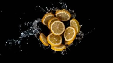 Su ve siyah arka planlı limon dilimlerinin süper yavaş çekimleri. Yüksek hızlı sinema kamerası, 1000 fps. İyi atıştı. Hız rampası etkisi.