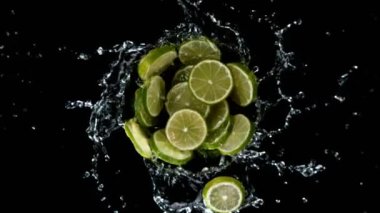 Su sıçratan limon dilimlerinin süper yavaş çekimleri, siyah arkaplan. Yüksek hızlı sinema kamerası, 1000 fps. İyi atıştı. Hız rampası etkisi.
