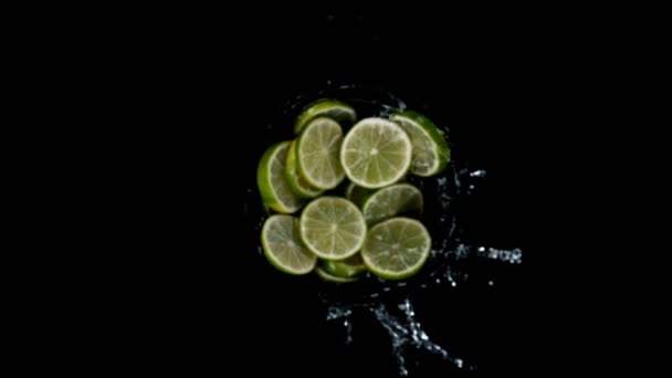 Super Slow Motion Rotating Lime Slices Splashing Water Black Background — Stock Video
