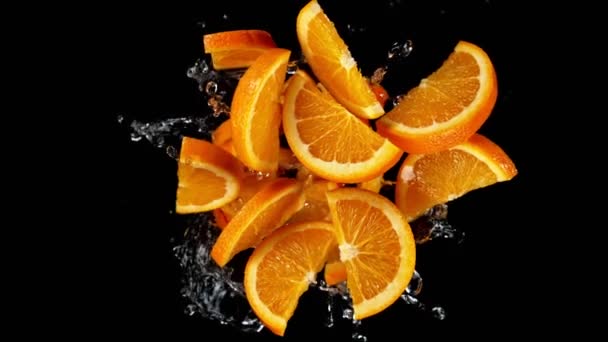 Super Langzame Beweging Van Sinaasappelschijfjes Draaiend Water Zwarte Achtergrond Gefilmd — Stockvideo