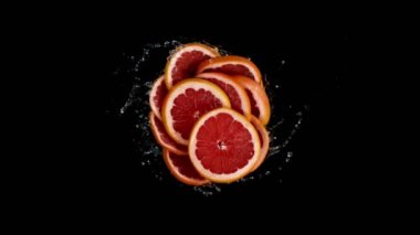 Su sıçratan Greyfurt dilimlerinin süper yavaş çekimleri, siyah arkaplan. Yüksek hızlı sinema kamerası, 1000 fps..