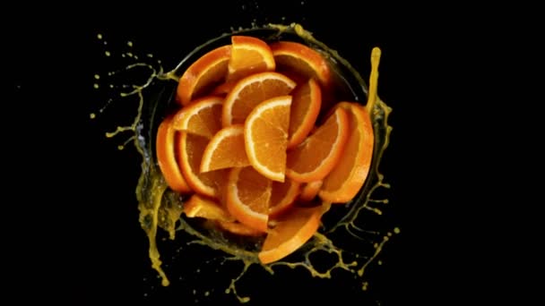 Super Slow Motion Rotating Orange Slices Splash Juice Black Background — Stock Video