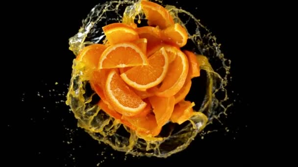 Super Slow Motion Rotating Orange Slices Splash Juice Black Background — Stock Video