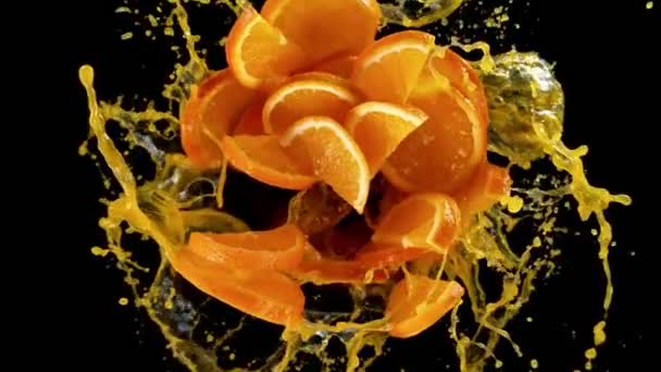 Super Slow Motion Van Roterende Sinaasappelschijfjes Met Splash Juice Zwarte — Stockvideo