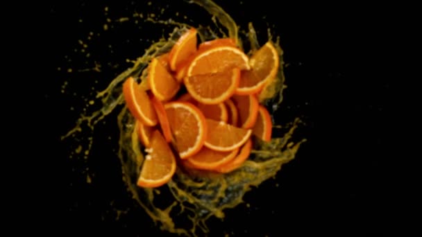 Super Slow Motion Rotating Orange Slices Splash Juice Black Background — Stock Video