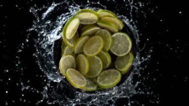 Su sıçratan limon dilimlerinin süper yavaş çekimleri, siyah arkaplan. Yüksek hızlı sinema kamerası, 1000 fps..