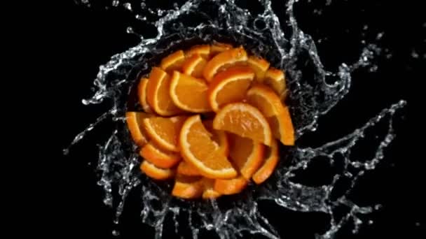 Super Zeitlupe Von Rotierenden Orangenscheiben Mit Spritzwasser Schwarzer Hintergrund Gefilmt — Stockvideo