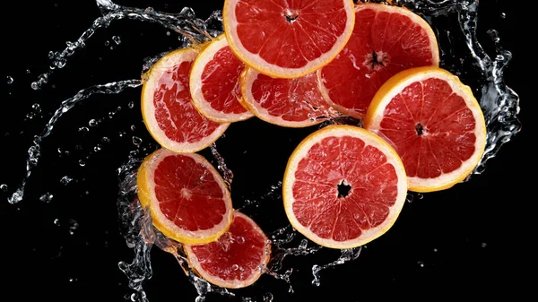 Bevriezen Beweging Van Gesneden Grapefruits Water Spatten Geïsoleerd Zwarte Achtergrond — Stockfoto