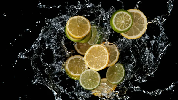 Bevriezen Beweging Van Gesneden Limoenen Citroenen Water Spatten Geïsoleerd Zwarte — Stockfoto