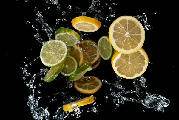 Congele Movimento Limas Fatiadas Limões Respingo Água Isolado Fundo Preto — Fotografia de Stock
