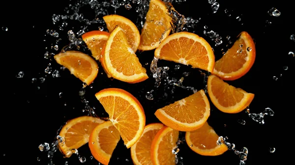 Zmrazit Pohyb Krájených Pomerančů Vodní Tříšti Izolováno Černém Pozadí — Stock fotografie