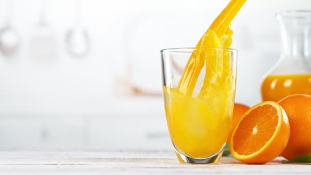 Супер Повільний Рух Заливання Апельсинового Соку Склянку Поміщений Білому Столі — стокове відео
