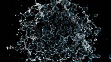 Dönen yaban mersini, siyah arka planda izole edilmiş, su sıçratıyor. Hareketi dondur.