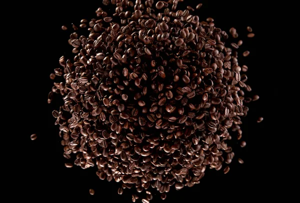 黒い背景に隔離された ツイスター状に飛ぶコーヒー豆の凍結運動 — ストック写真
