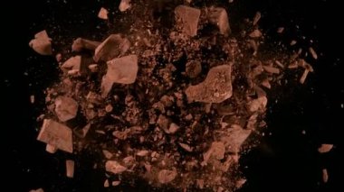 Siyah zemin üzerinde dönen bir grup çiğ çikolata parçasının süper yavaş çekimi. Yüksek hızlı sinema kamerası, 1000fps.