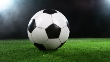 Çimlerde dönen futbol topunun süper yavaş çekimi. Yüksek hızlı sinema kamerası, 1000fps.