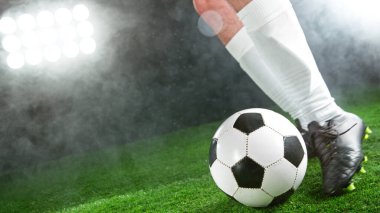 Futbolcu çimlerde top tekmeliyor, detaylı atış. Futbol arkaplanı.