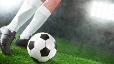 Futbolcu çimlerde top tekmeliyor, detaylı atış. Futbol arkaplanı.