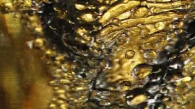 Su sıçratma yağının süper yavaş akışı. Makro soyut çekim. Yüksek hızlı sinema kamerası, 1000fps.