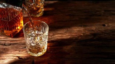 Super slow motion of pouring whiskey into glass. Placed on old wooden table. Filmed on high speed cinema camera, 1000fps. Speed ramp effect.