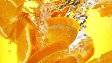 Su altında dönen portakal dilimlerinin süper yavaş çekimi. Yüksek hızlı sinema kamerası, 1000 fps..