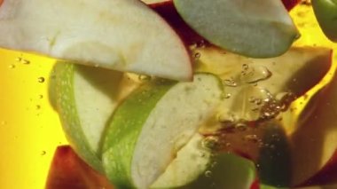 Dilimlenmiş elmaları suyun altında döndürmek için süper yavaş çekim. Yüksek hızlı sinema kamerası, 1000 fps. Hız rampası etkisi.