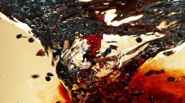 Meyve çayını suya karıştırıp hortum şeklinde döndürmeye çalış. Altın arka planda izole edilmiş.