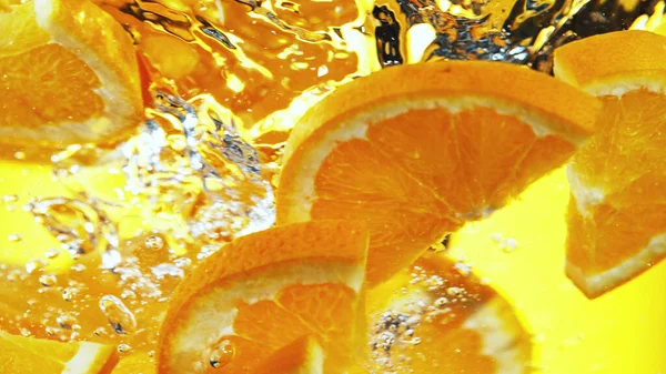 Uzavřete Oranžové Plátky Vodě Izolováno Žlutém Pozadí — Stock fotografie