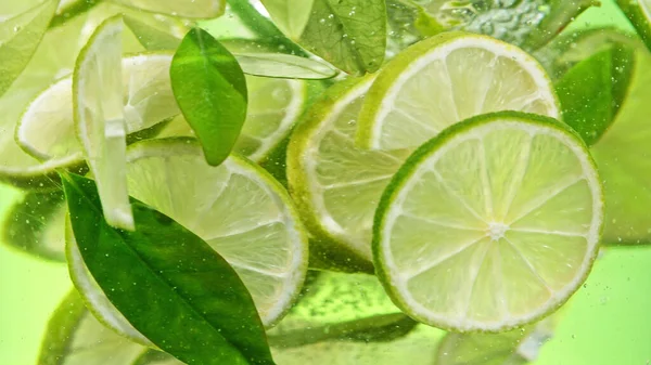 Close Lime Slices Water Isolated Yellow Background —  Fotos de Stock