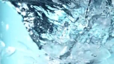 Suda dönen buz küplerinin süper yavaş hareketi. Yüksek hızlı sinema kamerası, 1000 fps. Su altı bileşimi.