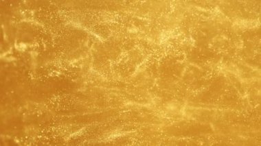 Super slow motion of glittering golden particles in water. Abstract luxury style background. Filmed on high speed cinema camera, 1000 fps.