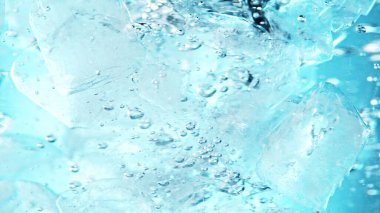 Su altında buz küplerini kapatın, mavi arkaplan. Suda akan buzun dondurucu hareketi.