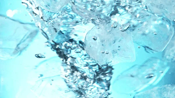 氷のキューブの水中 青の背景を閉じます 水に流れる氷の凍結運動 — ストック写真
