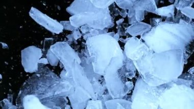 Siyah zemin üzerine düşen buz parçasının süper yavaş çekimi. Yüksek hızlı sinema kamerası, 1000 fps..